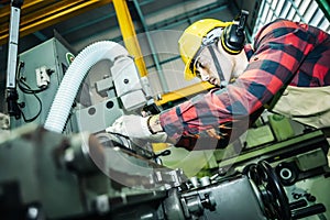 Asian worker wearing the goggle, helmet, ear muff equipment in production plant