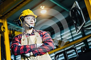 Asian worker wearing the goggle, helmet, ear muff equipment in production plant