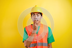 Asian worker wearing a helmet looks shocked hearing the news