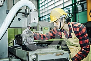 Asian worker wering the goggle, helmet, ear muff equipment in production plant