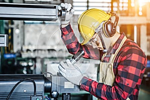 Asian worker wering the goggle, helmet, ear muff equipment in production plant photo