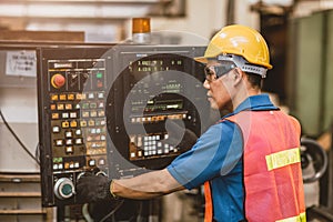 Asian worker work with Automated Digital Lathe CNC Metal Machine. Engineer Setup Operate Programming Milling Machine in Factory