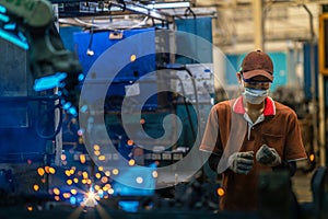 Asian worker working in old chinese factory in robot auto welding machine section