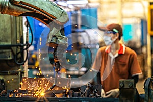 Asian worker working in old chinese factory in robot auto welding machine section