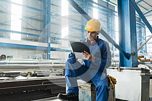 Asian worker writing observations about manufacturing