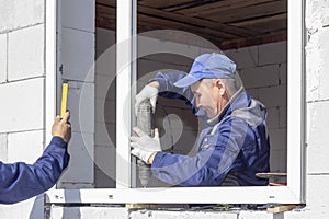 Asian workers install windows to the house