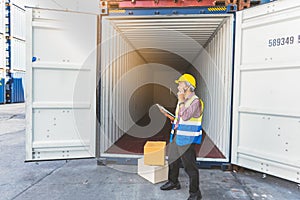 Asian workers man, Using a communication radio and working in containers industry