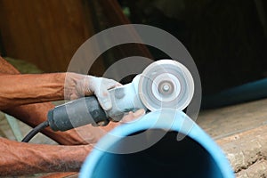 Asian workers use circular saw cutting the PVC pipe
