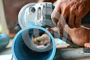 Asian workers use circular saw cutting the PVC pipe