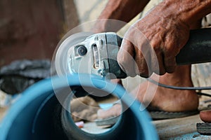 Asian workers use circular saw cutting the PVC pipe