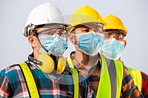 Asian workers wear protective face masks for safety in Construction site. New normal