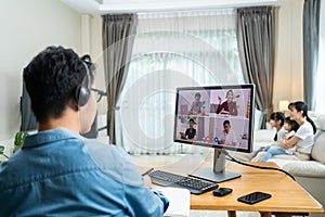 Asian Working business man father talk to colleagues team on virtual video call conference online. Male freelance worker using lap
