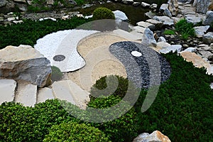 Asian Yin and Yang symbol of contrary and complementary forces made as stone decoration with pathway in Mu-Shin garden photo