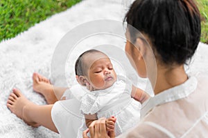 Asian young beautiful mother holding her newborn is sleeping and feel with love and touching gently