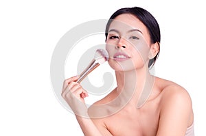 Asian young beautiful woman looking and touch her chin with powder brush,natural makeup, skincare, cosmetology and plastic surgery