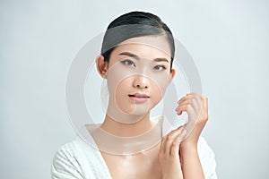 Asian young beautiful woman smiling and touching her face, isolated over white background