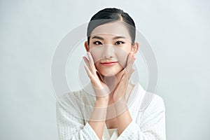 Asian young beautiful woman smiling and touching her face, isolated over white background