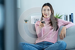 Asian young beautiful woman watching fun movie on television at home. Attractive casual girl feel happy and relax, sit on sofa