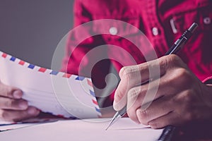 Asian young business man of student holding a pen writing letter on paper at home