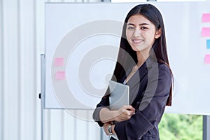 asian young business woman holding Digital tablet Computer isolated on White board background in office.smiling secretary girl wi photo