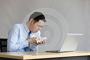 Asian young businessman have a coughing and holding tissue paper with phlegm in office photo