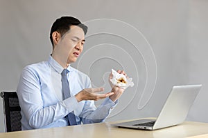 Young businessman have a coughing and holding tissue paper with phlegm in office photo