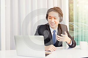 Asian young businessman smile wearing headphones and suit video conference call