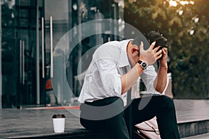 Asian young businessman stress sitting in front office with his