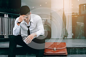Asian young businessman stress sitting in front office with his