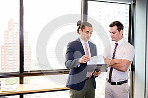 Asian young businessman two people holding clipboard and discussing work in the meeting room