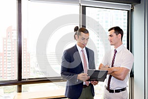 Asian young businessman two people holding clipboard and discussing work in the meeting room