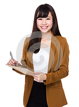 Asian Young Businesswoman take note on clipboard