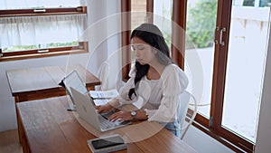 Asian young businesswoman is working at cafe using her laptop with focus