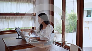 Asian young businesswoman is working at cafe using her laptop with focus