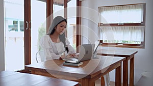 Asian young businesswoman is working at cafe using her laptop with focus