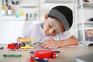 Asian Young Child Concentrate and Focus on Connecting Electronic Constructor. Learning and Experimentation with Circuit Board at