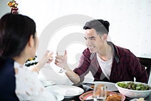 Asian young couple enjoying a romantic dinner  evening drinks while sitting at the dinning table on the kitchen together