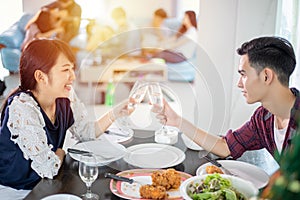 Asian young couple enjoying a romantic dinner  evening drinks while sitting at the dinning table on the kitchen together