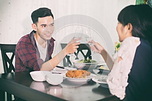 Asian young couple enjoying a romantic dinner evening drinks wh