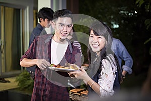 Asian young couple enjoying a romantic dinner and group of frie