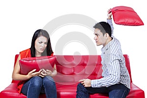 Asian young couple fighting with pillows