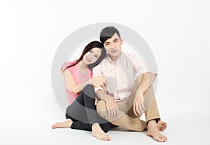 Asian young couple sitting on floor isolated on white background