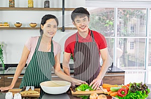Asian young couple. Are standing smile cooking in the kitchen.