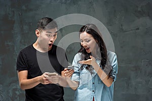 Asian young couple using cellphone, closeup portrait.