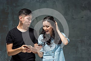 Asian young couple using cellphone, closeup portrait.