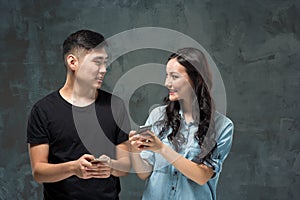 Asian young couple using cellphone, closeup portrait.