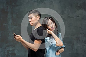 Asian young couple using cellphone, closeup portrait.