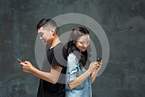 Asian young couple using cellphone, closeup portrait.