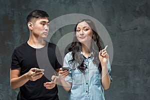 Asian young couple using cellphone, closeup portrait.