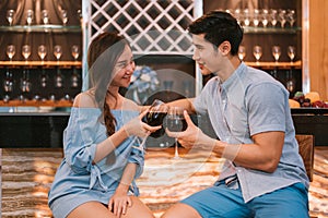 Asian young couples clinking wine glasses at domestic bar of lux photo